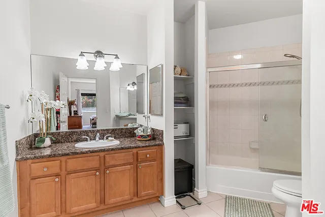 a bathroom with a granite countertop sink a mirror and a bathtub