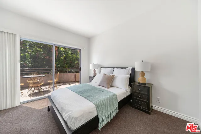 a bedroom with a bed and large window