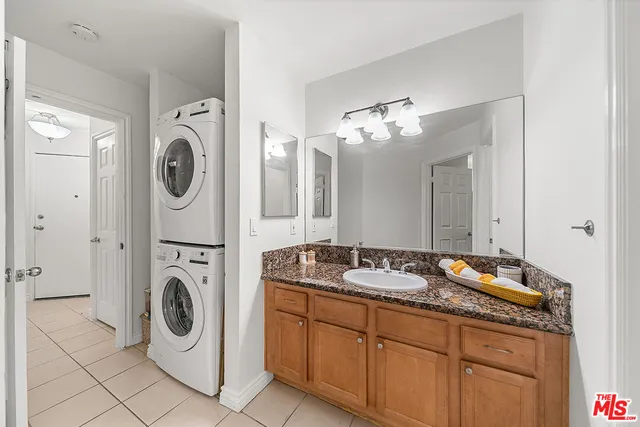 a spacious bathroom with a granite countertop sink and a mirror