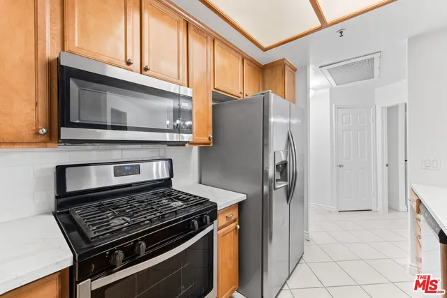a kitchen with stainless steel appliances granite countertop a refrigerator stove and cabinets
