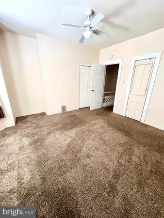 an empty room with windows and fan