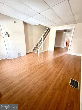 a view of an empty room with wooden floor