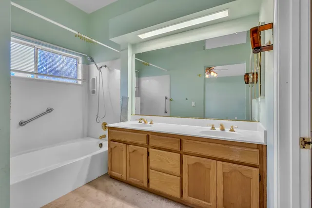 a bathroom with a tub sink and mirror