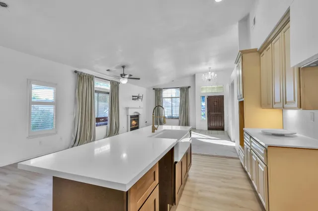 a large kitchen with stainless steel appliances granite countertop a sink dishwasher a stove and a dining table with wooden floor