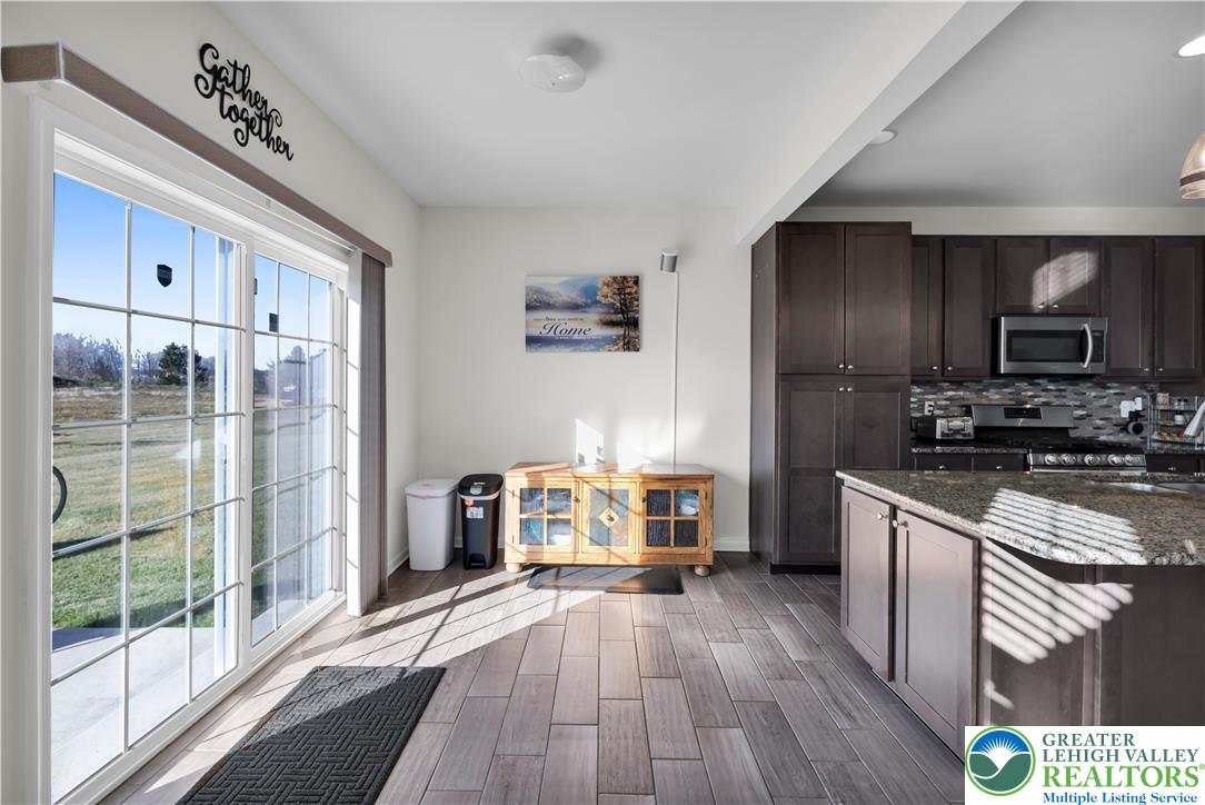 4247 Beech Drive Nazareth, PA 18064 - Photo 12 of 42 a kitchen with granite countertop a stove a sink dishwasher a refrigerator and a fireplace with wooden floor