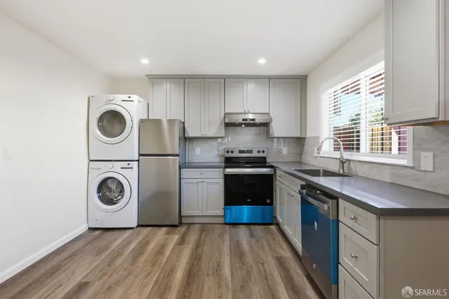 a kitchen with stainless steel appliances granite countertop a stove a sink and a refrigerator
