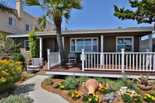 a front view of a house with a yard and potted plants