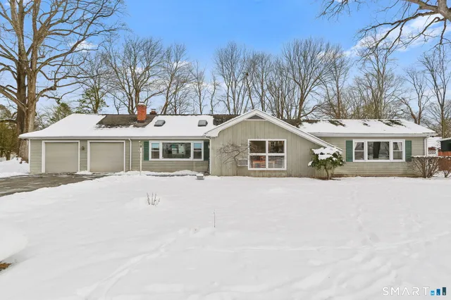 a front view of a house with a yard covered in snow