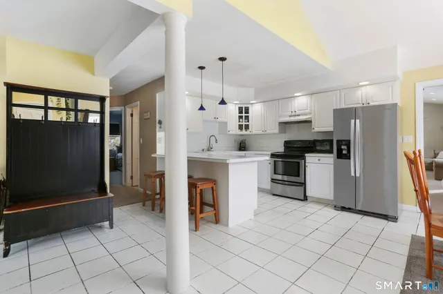 a kitchen with granite countertop a refrigerator and a stove top oven