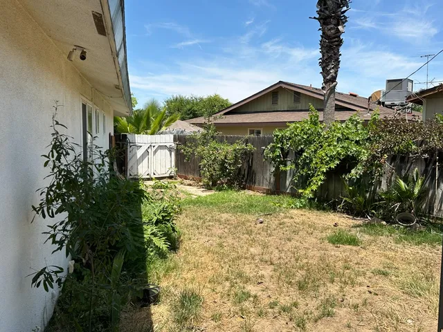 a view of a house with a yard and potted plants