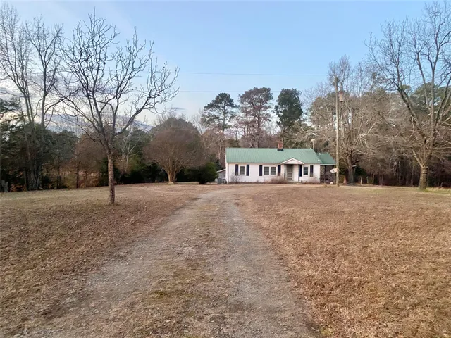 a front view of a house with a yard and mountain view in back