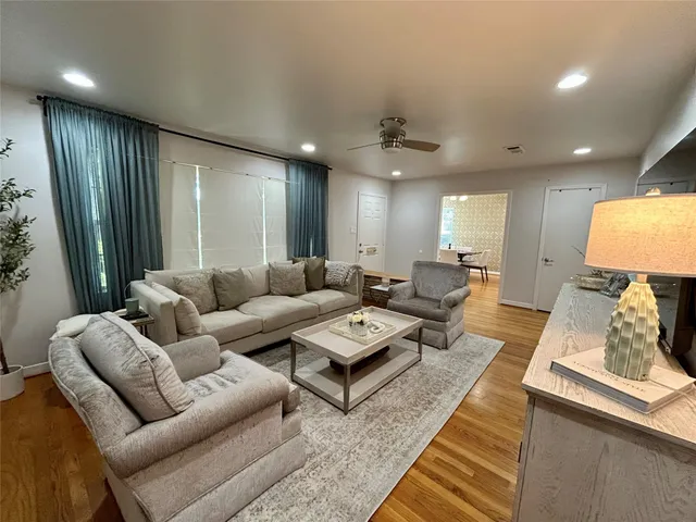 a living room with furniture and a wooden floor