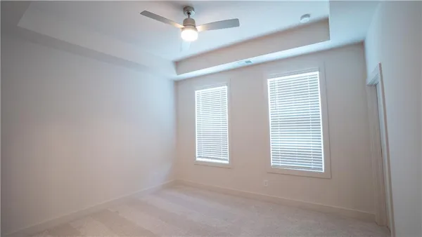 an empty room with a window and ceiling fan
