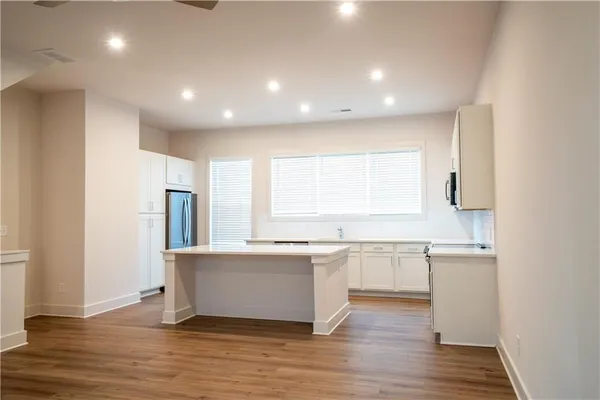 a large kitchen with stainless steel appliances granite countertop a lot of counter space and wooden floor