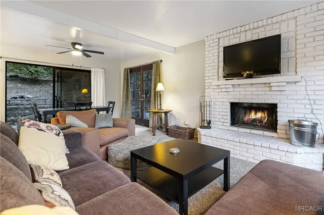 a living room with furniture a flat screen tv and a fireplace