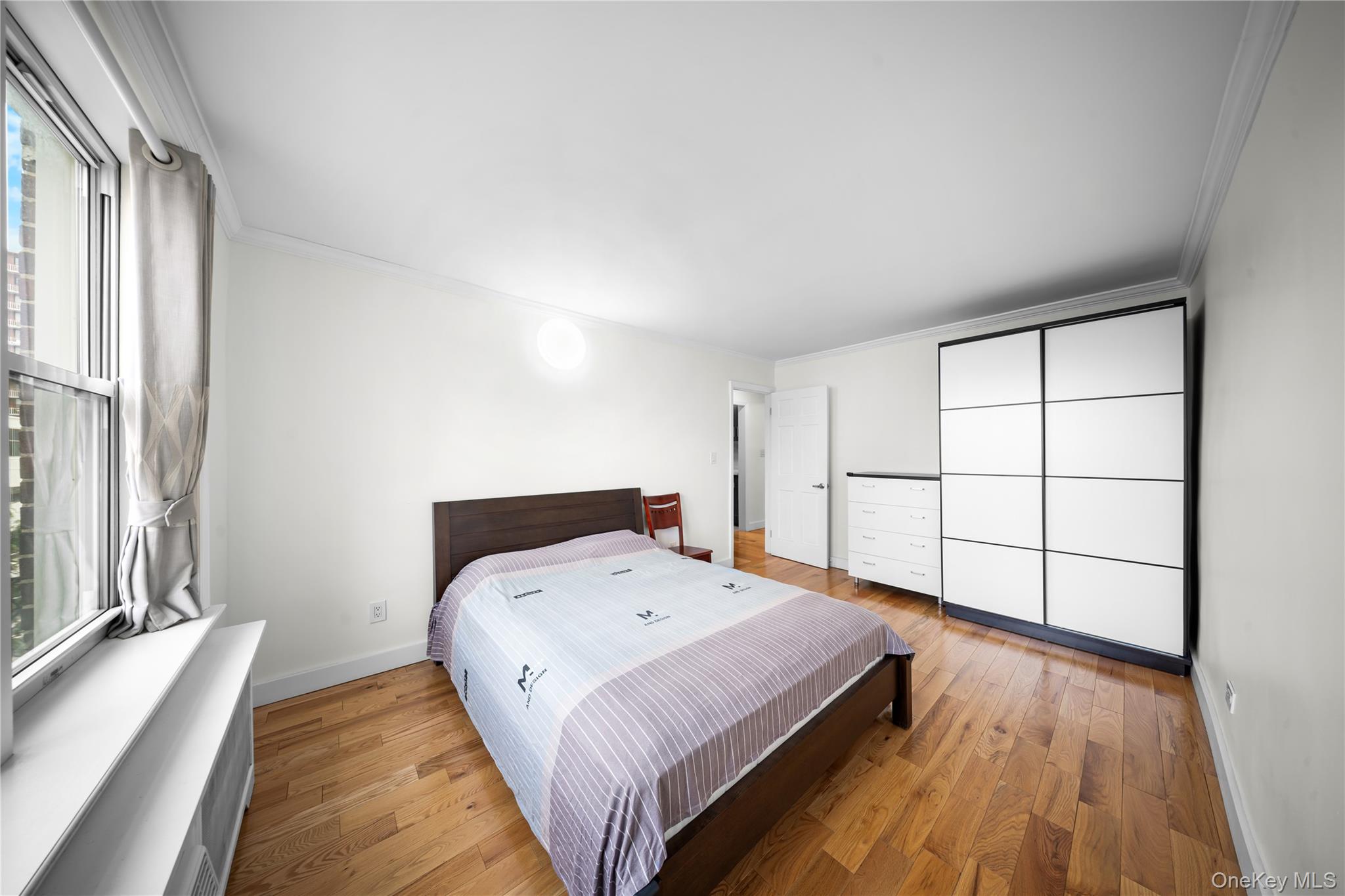 134-54 Maple Avenue, Unit 3W Queens, NY 11355 - Photo 13 of 19 Bedroom with crown molding and hardwood / wood-style flooring