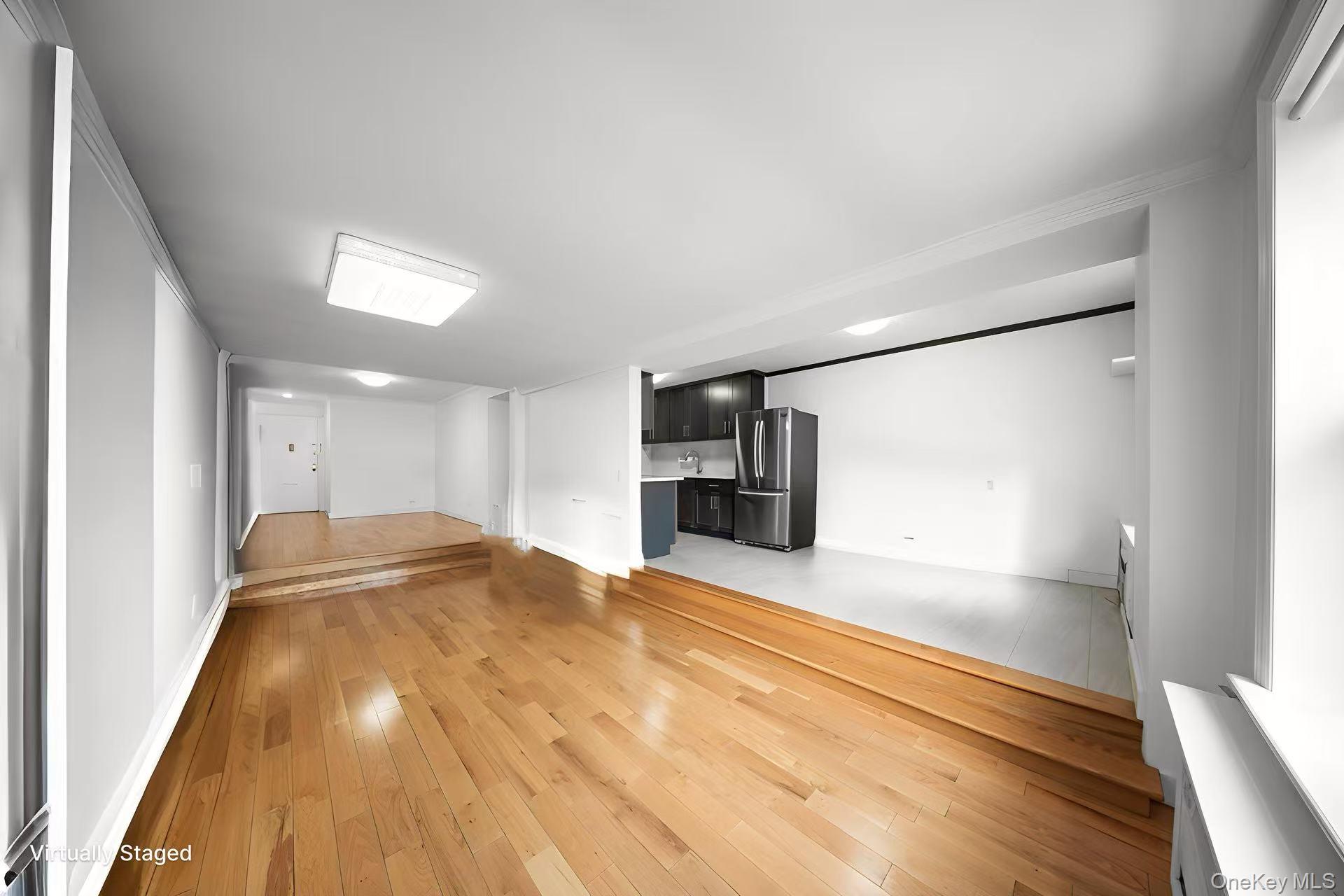 134-54 Maple Avenue, Unit 3W Queens, NY 11355 - Photo 7 of 19 Unfurnished living room with light wood-style floors and baseboards