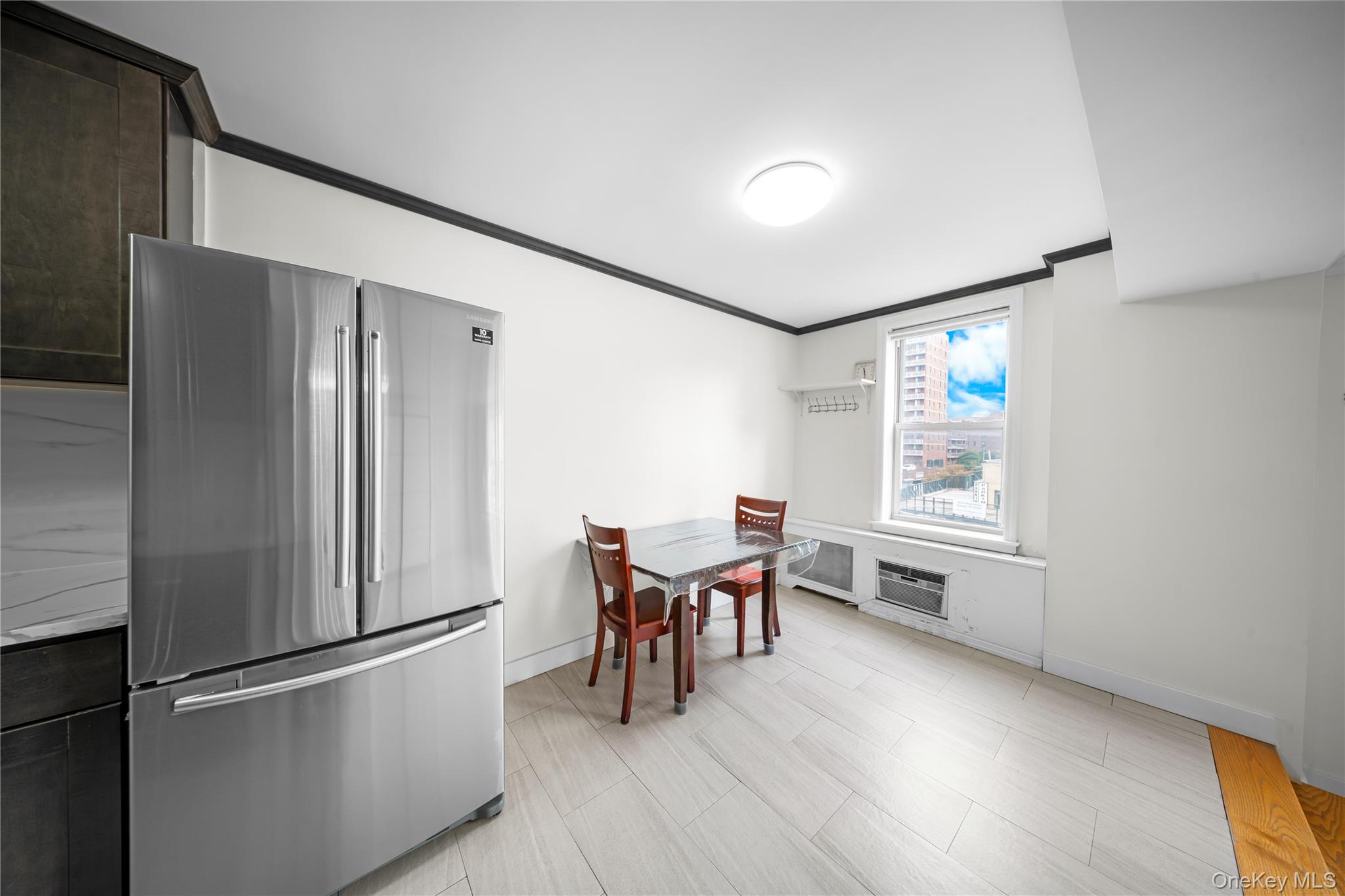 134-54 Maple Avenue, Unit 3W Queens, NY 11355 - Photo 9 of 19 Kitchen with freestanding refrigerator, ornamental molding, and dark brown cabinets