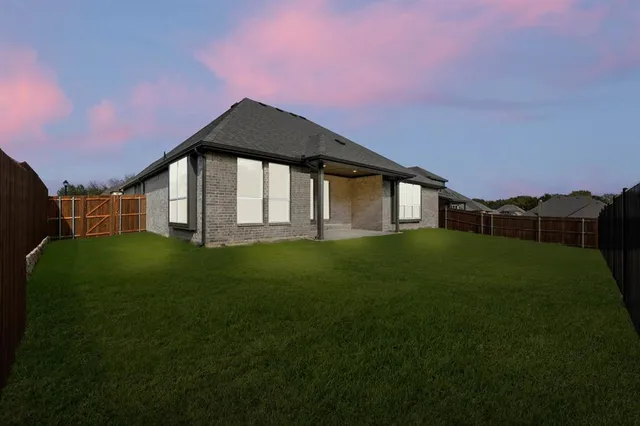 a view of a big house with a big yard and potted plants