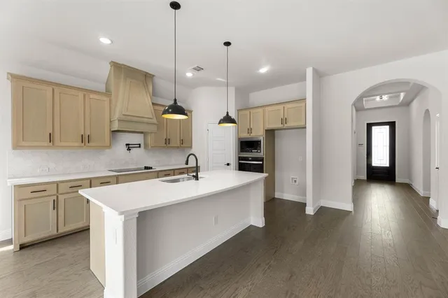 a kitchen with a sink a counter top space stainless steel appliances and cabinets