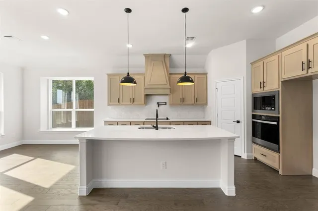 a kitchen with kitchen island a sink stove and refrigerator