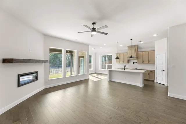 a large kitchen with stainless steel appliances kitchen island a large counter top and a wooden floors