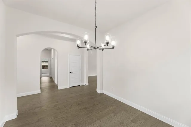 a view of empty room with wooden floor and ceiling fan