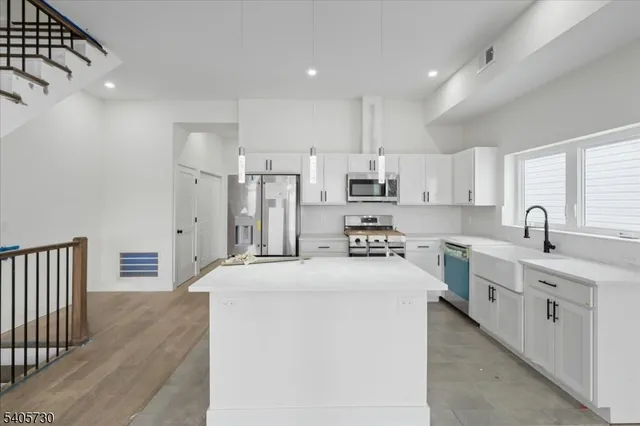 a kitchen with stainless steel appliances a refrigerator sink and cabinets