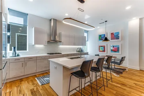 a kitchen with cabinets a sink and chairs in it