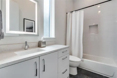 a bathroom with a granite countertop sink toilet and shower