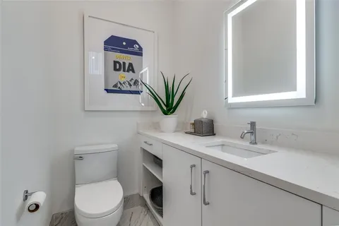 a bathroom with a toilet a sink and mirror