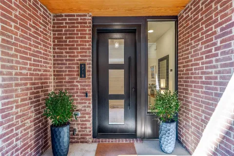 a view of a brick house with potted plants