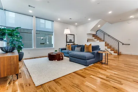 a living room with furniture and a wooden floor