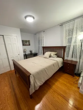 a bedroom with a bed and wooden floor