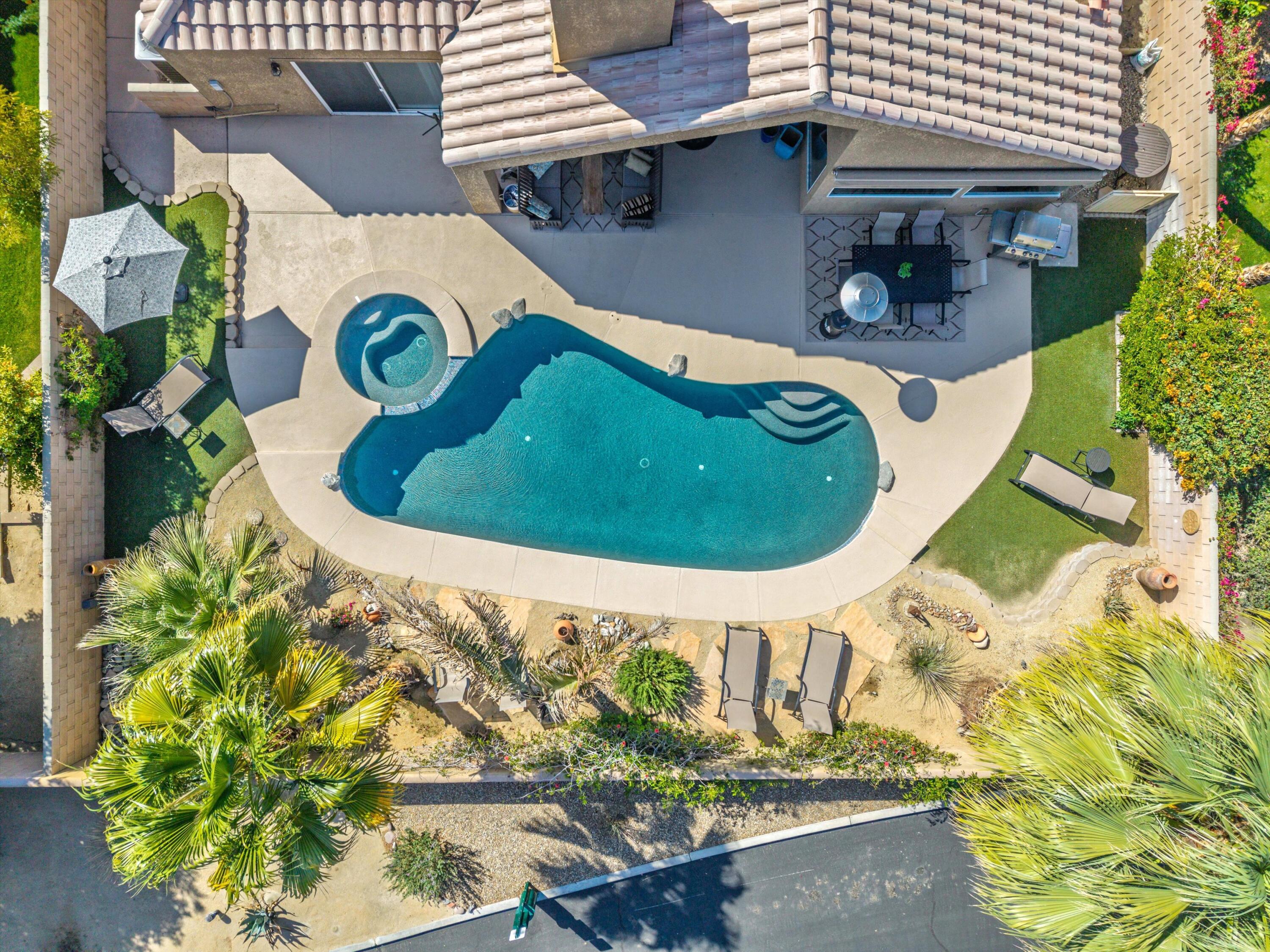 78330 Vía Sevilla La Quinta, CA 92253 - Photo 12 of 49 a view of a swimming pool with a yard and plants