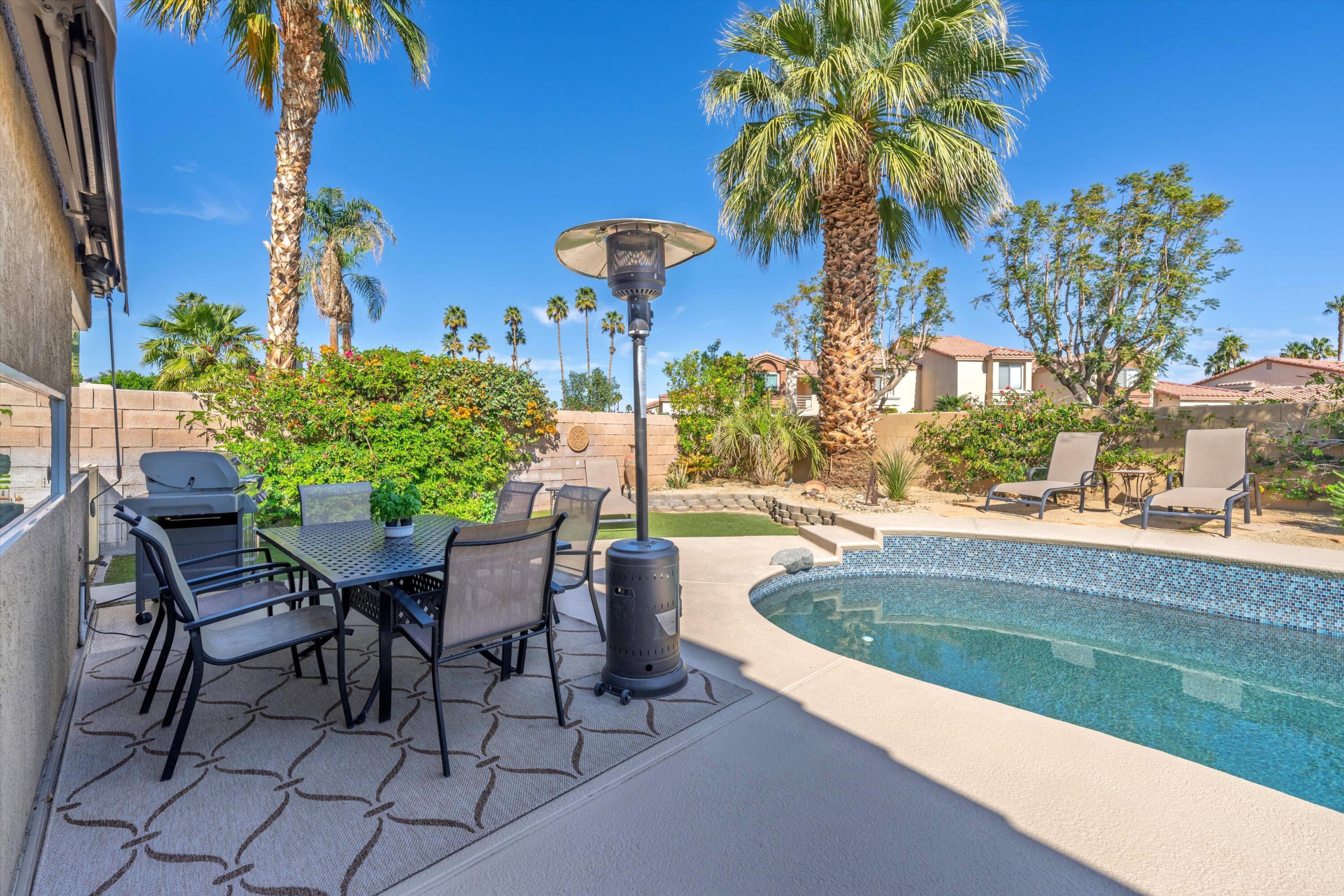 78330 Vía Sevilla La Quinta, CA 92253 - Photo 17 of 49 a view of a swimming pool with a table and chairs