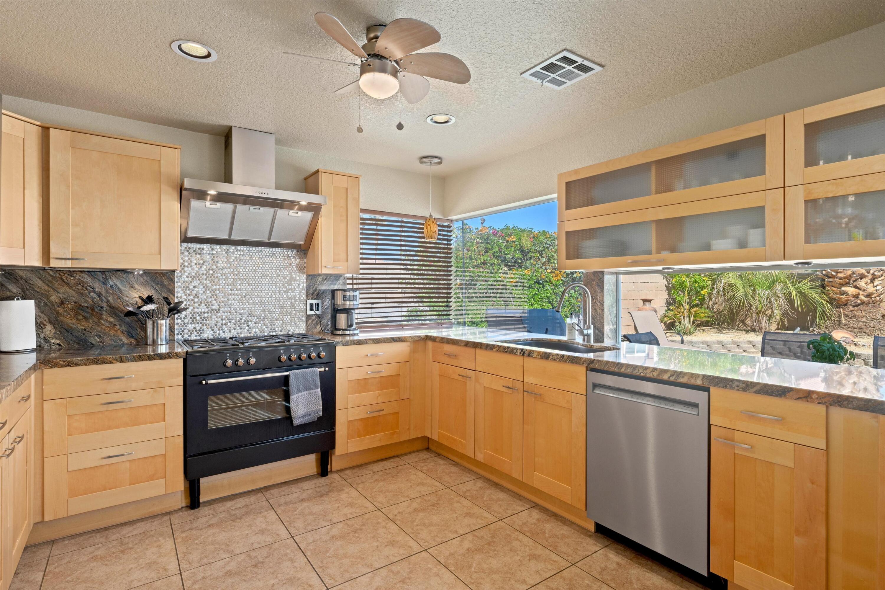 78330 Vía Sevilla La Quinta, CA 92253 - Photo 38 of 49 a kitchen with stainless steel appliances granite countertop a sink and cabinets