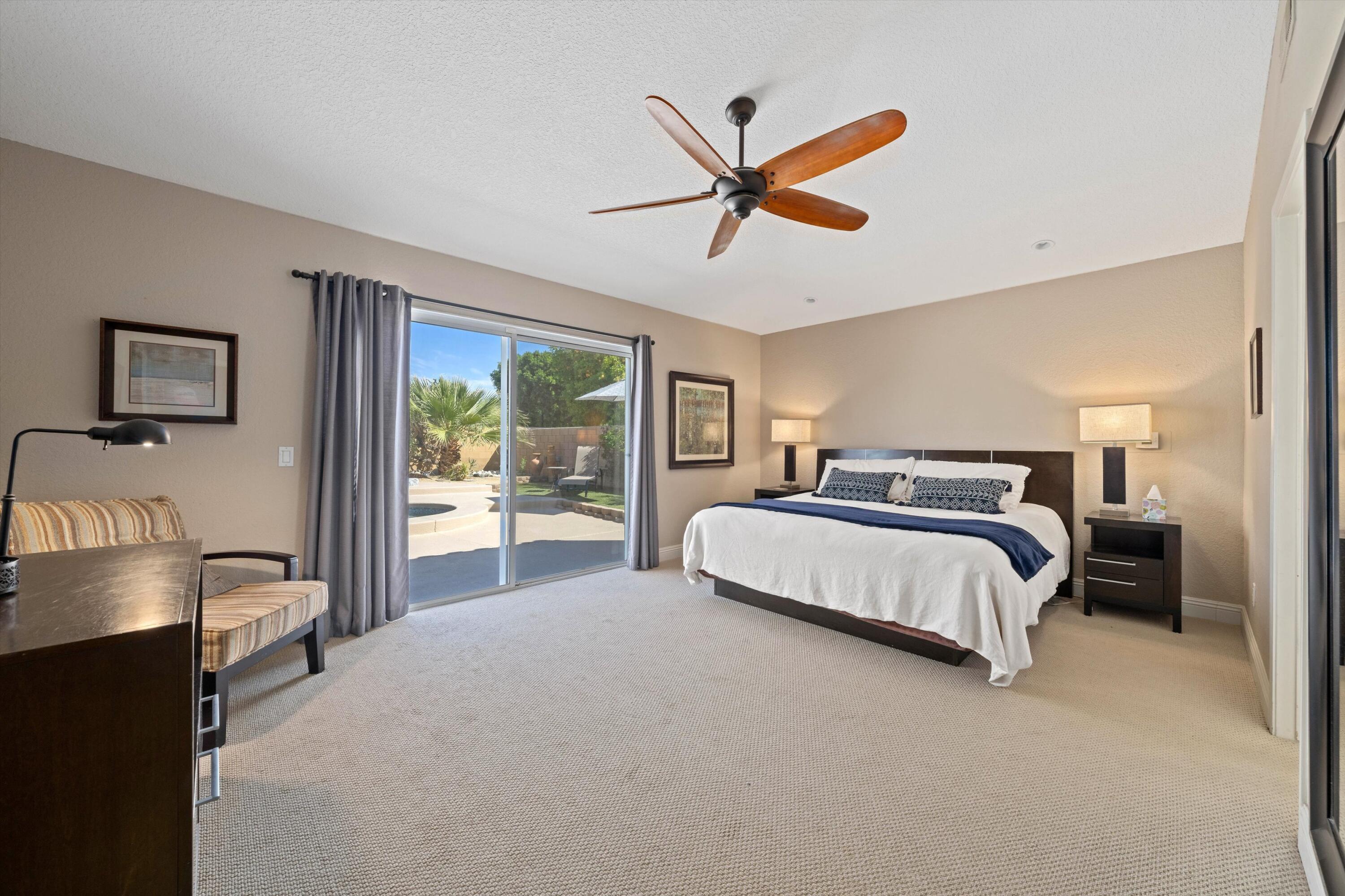 78330 Vía Sevilla La Quinta, CA 92253 - Photo 41 of 49 a bedroom with a large bed and a chandelier