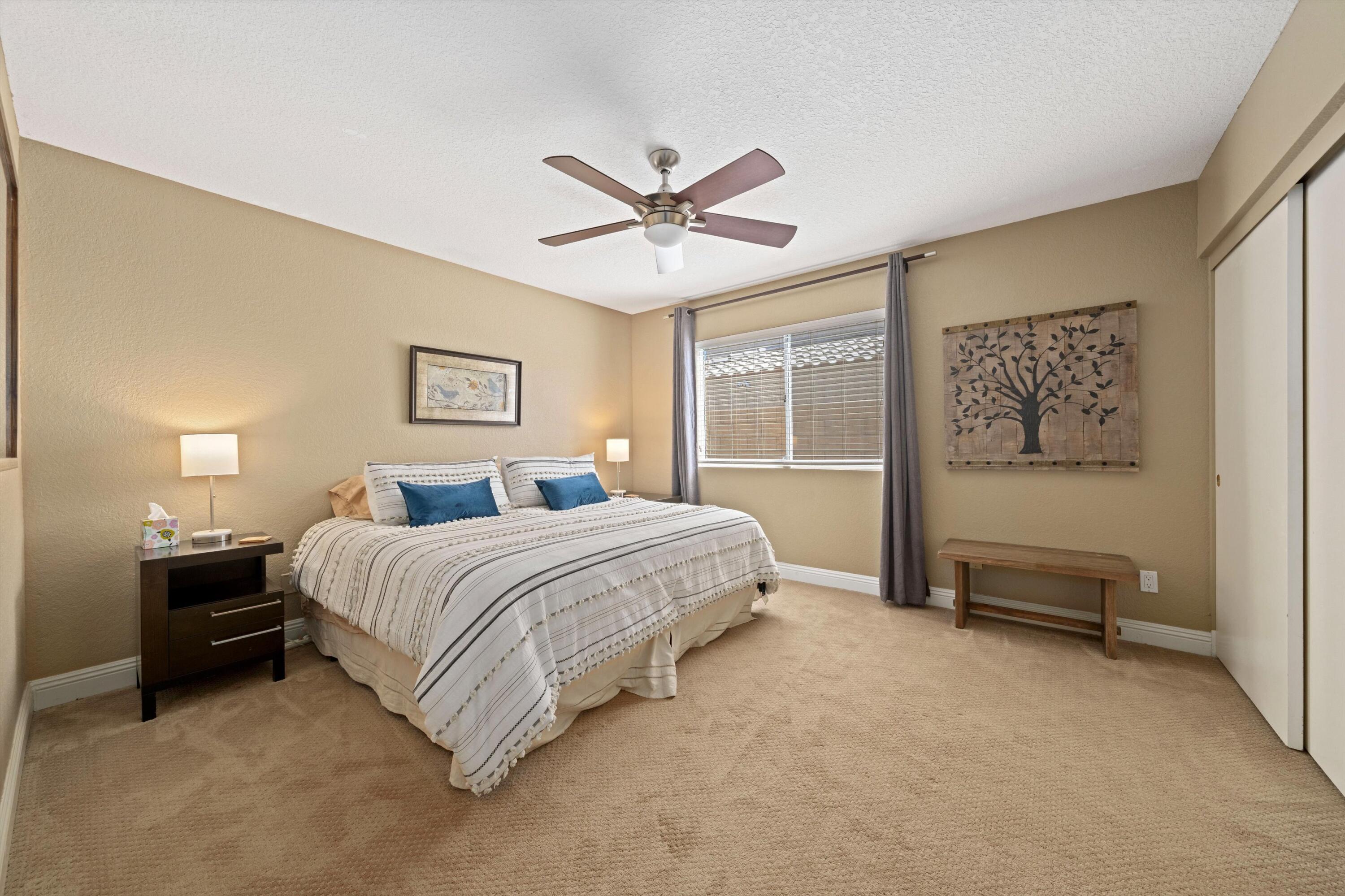 78330 Vía Sevilla La Quinta, CA 92253 - Photo 48 of 49 a spacious bedroom with a bed and a chandelier