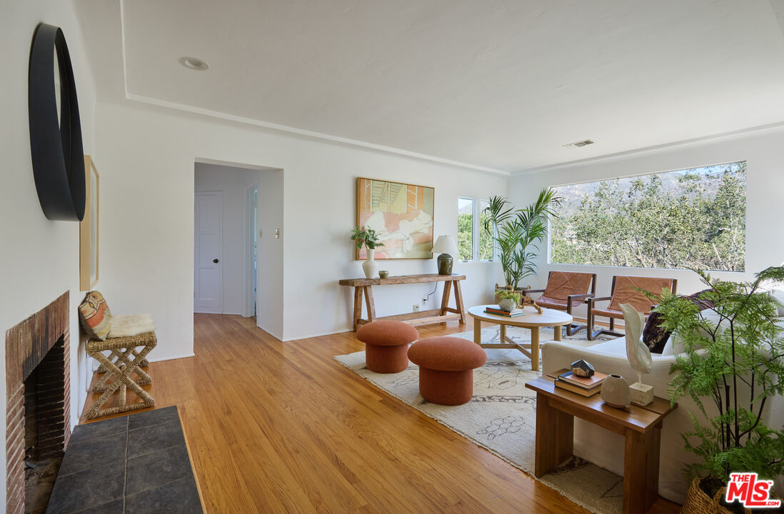 6948 St Estaban Street Tujunga, CA 91042 - Photo 1 of 26 a living room with furniture a flat screen tv and a floor to ceiling window