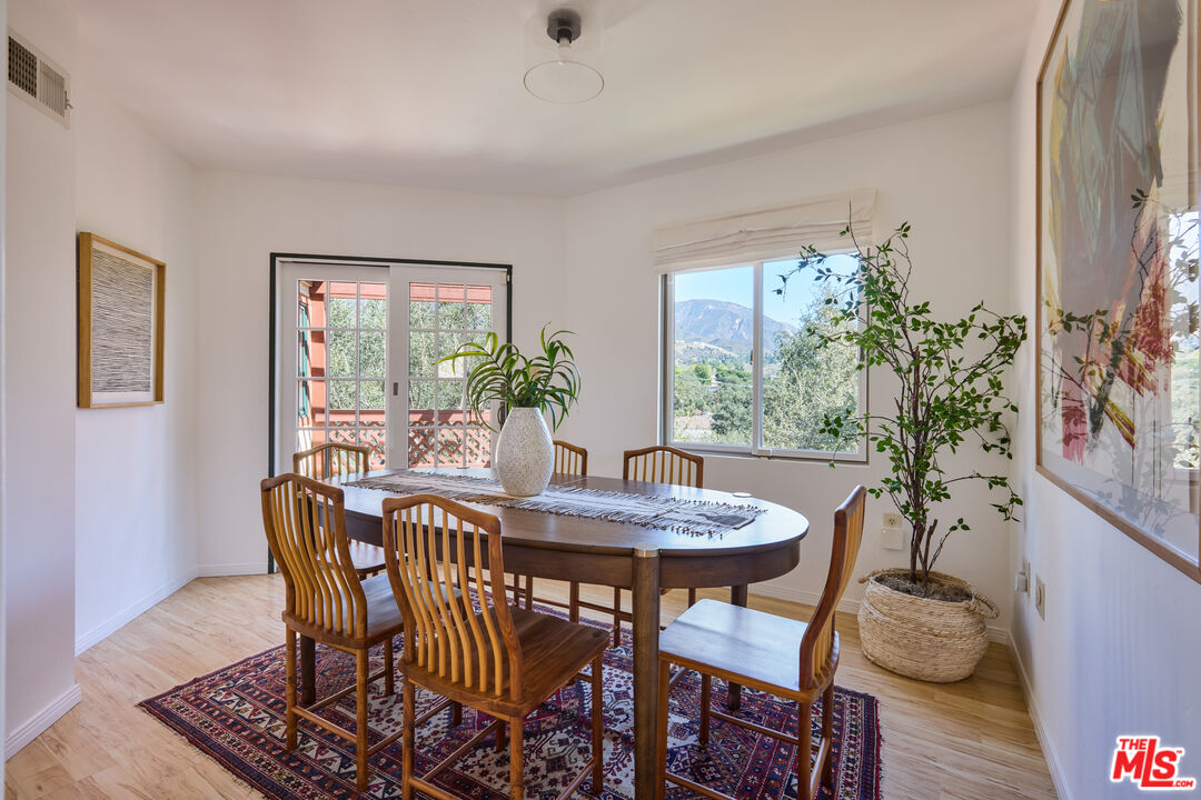 6948 St Estaban Street Tujunga, CA 91042 - Photo 14 of 26 a dining room with furniture potted plants and wooden floor