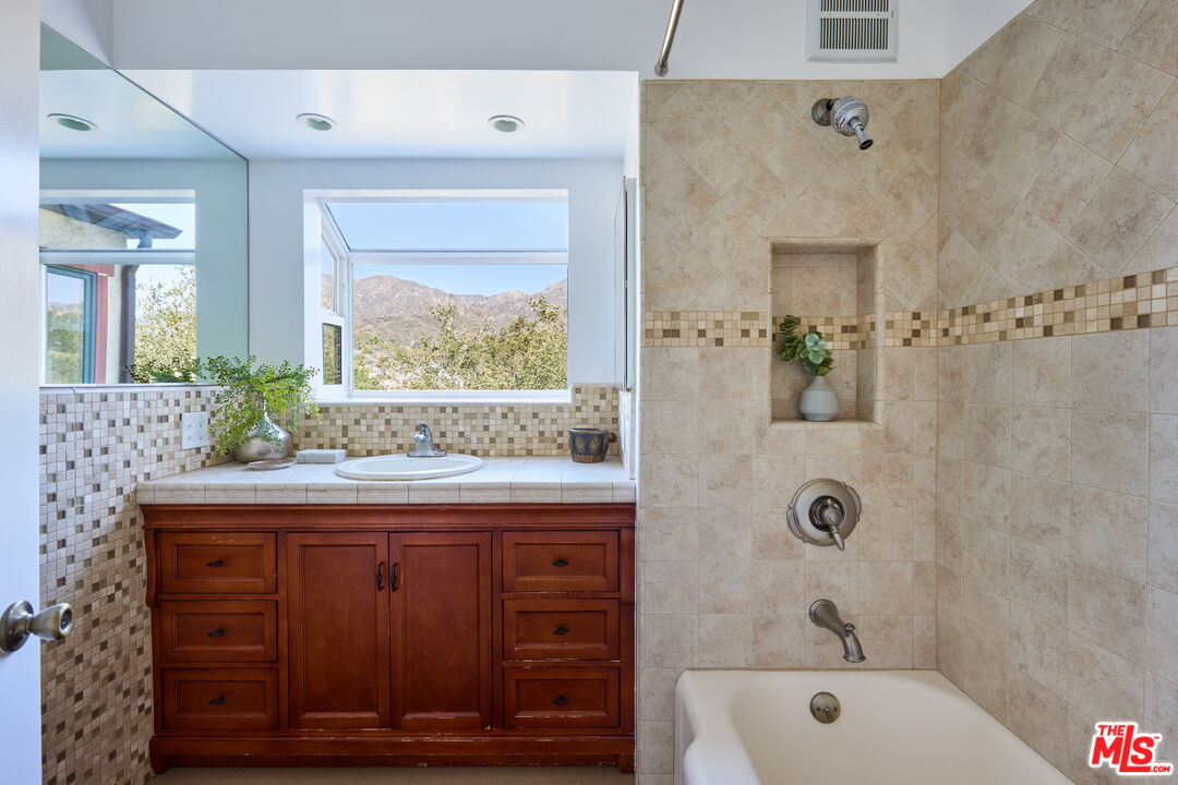 6948 St Estaban Street Tujunga, CA 91042 - Photo 22 of 26 a bathroom with a granite countertop sink a toilet and shower
