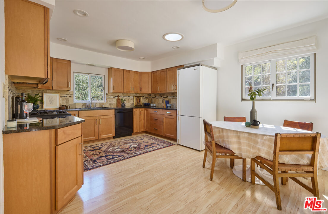 6948 St Estaban Street Tujunga, CA 91042 - Photo 5 of 26 a kitchen with stainless steel appliances granite countertop a refrigerator a stove a sink dishwasher with a dining table and chairs