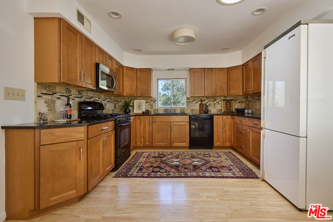 6948 St Estaban Street Tujunga, CA 91042 - Photo 6 of 26 a kitchen with stainless steel appliances granite countertop a refrigerator sink and cabinets