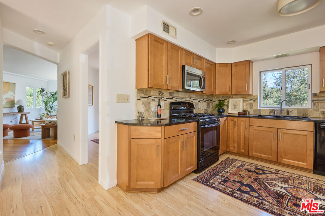 6948 St Estaban Street Tujunga, CA 91042 - Photo 7 of 26 a kitchen with stainless steel appliances granite countertop a refrigerator sink and microwave