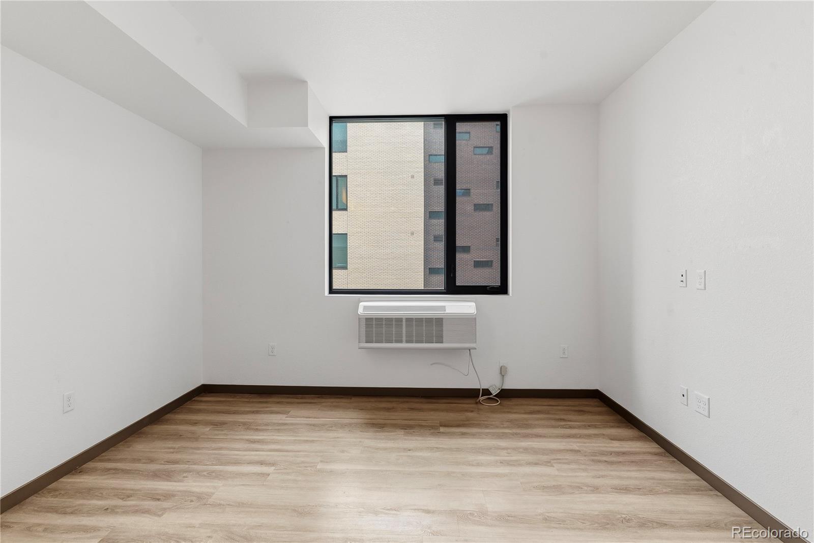 603 Inca Street, Unit 330 Denver, CO 80204 - Photo 11 of 18 a view of an empty room with wooden floor and a window
