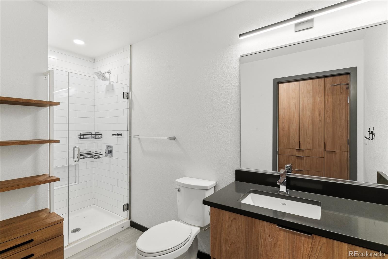 603 Inca Street, Unit 330 Denver, CO 80204 - Photo 18 of 18 a bathroom with a granite countertop sink toilet and shower