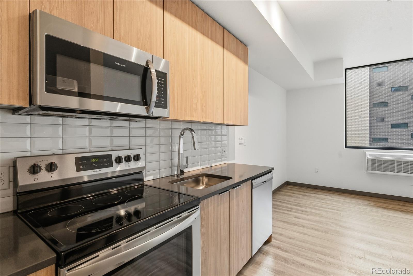 603 Inca Street, Unit 330 Denver, CO 80204 - Photo 6 of 18 a kitchen with a stove microwave and sink