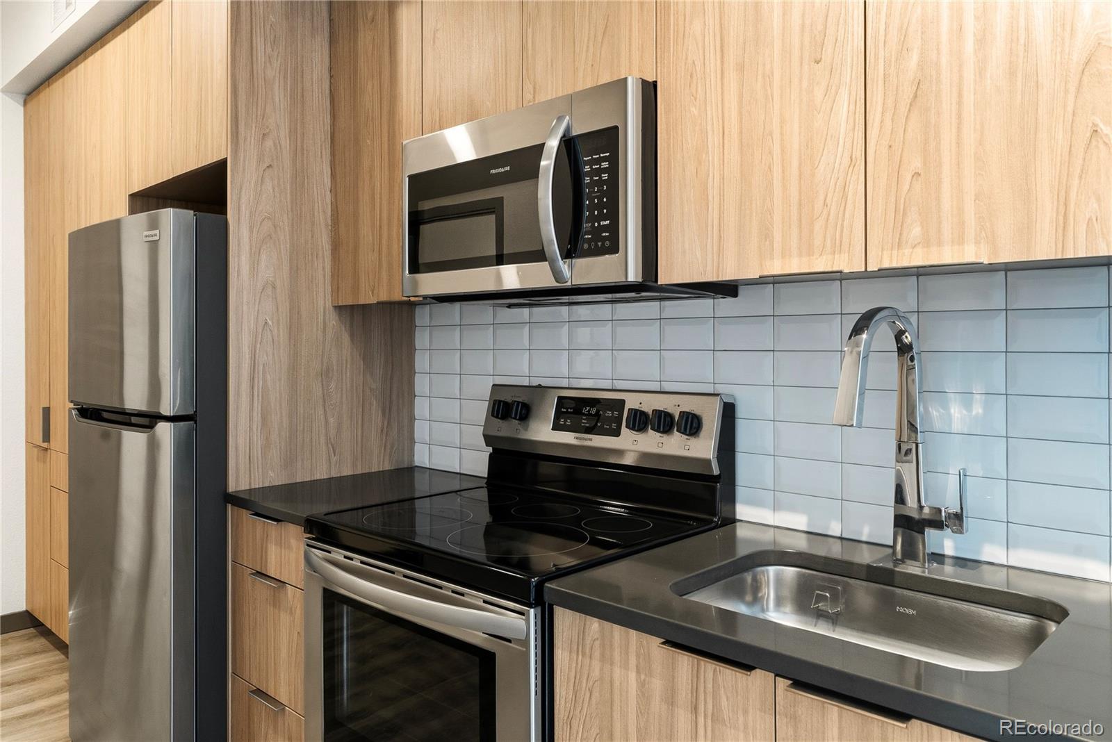 603 Inca Street, Unit 330 Denver, CO 80204 - Photo 9 of 18 a kitchen with stainless steel appliances granite countertop a sink stove and refrigerator
