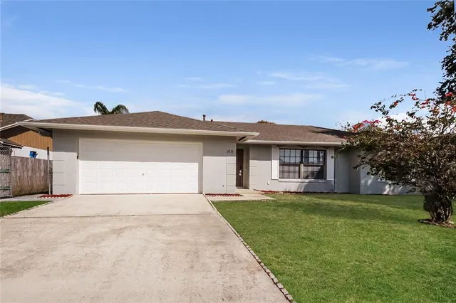 a view of a yard in front of a house with a large tree